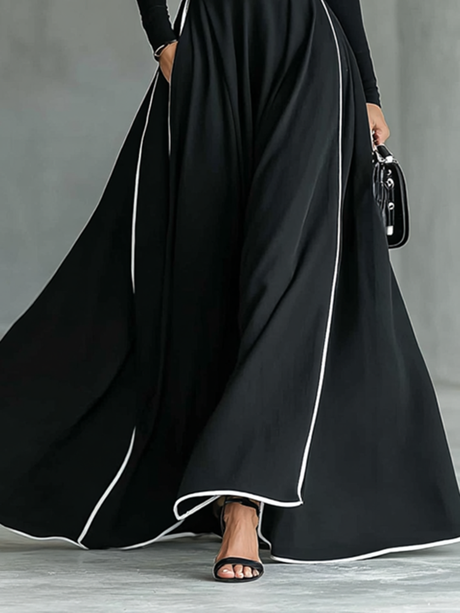 Robe longue noire avec bordure blanche, col montant, manches longues et ceinture